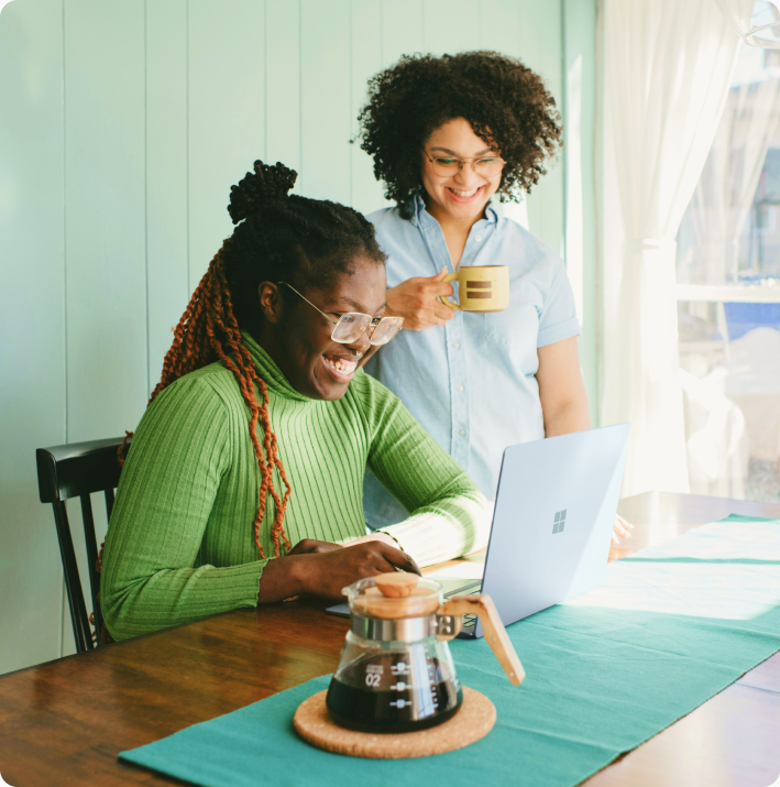 Two women looking at a laptop together at a table